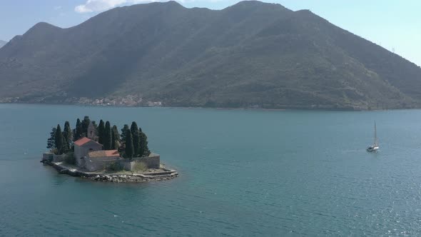 Drone flies around a small Island in the sea