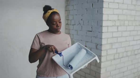 Portrait of Happy African-American Woman with Paint Roller alt