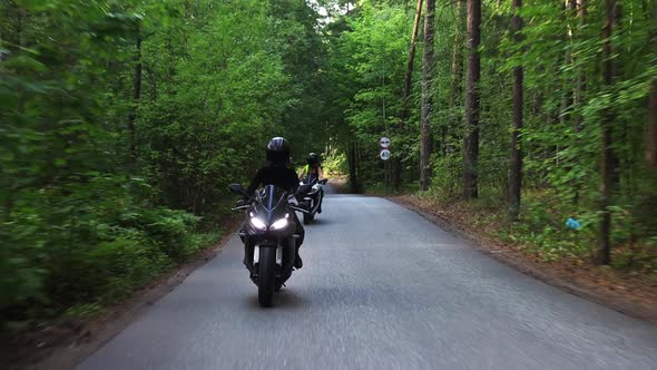 Motorbikes in the Forest  Two Adult Women Riding Motorcycles on the Empty Narrow Road alt