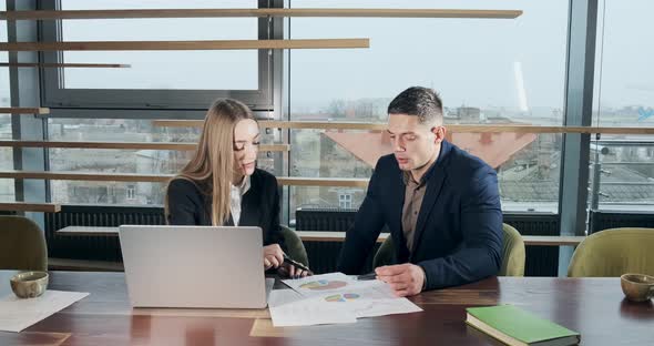 Man and a Woman Discussing Work in the Brightly Lit Modern Office. Concerned Male and Female Working alt