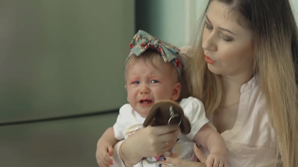 Young Beautiful Mother Calms Her Daughter, After Vaccination alt