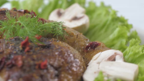 Fried Chicken Thighs on a Plate Decorated with Mushrooms and Lettuce alt