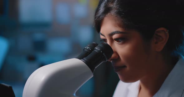 Female Research Scientist Looking at Samples Under Microscope alt