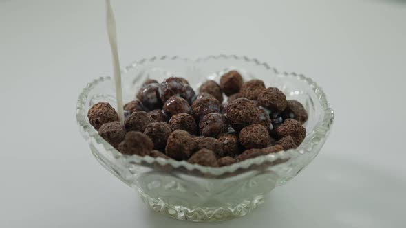 Milk Pouring on Chocolate Cocoa Balls in Glass Bowl alt