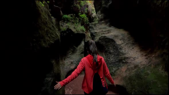 Young explorer walks through a narrow path in caves and caverns in Estrecho de la Arboleja, Spain. alt