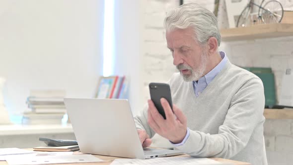 Old Man Using Smartphone for Online Work alt