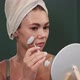 Young Woman Using Jade Facial Roller for Face Massage Sitting in Bathroom Looking in the Mirror Slow - VideoHive Item for Sale