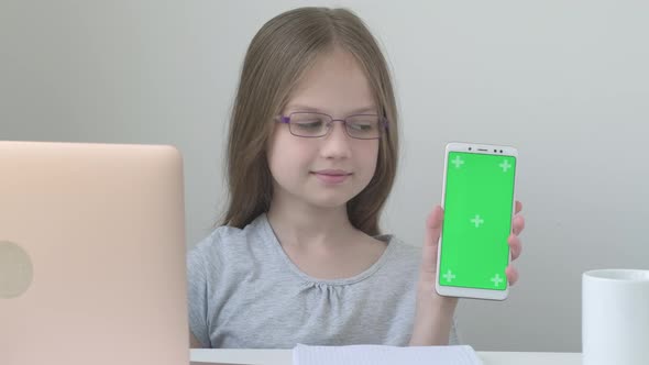 Schoolgirl in Glasses Shows Phone with Green Screen Mock Up Cellphone Mobile Telephone alt