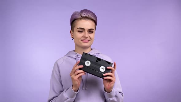 Trendy Female Person Turning VHS Cassette Tape in Hands Isolated alt