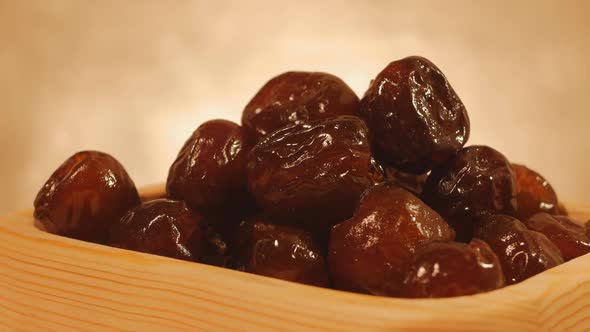 Pitted Turkish Dates in a Wooden Plate Rotate Cyclically