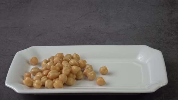 Cooked chickpeas (Cicer arietinum) in bowl on black background