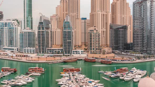 Luxury Yachts Parked on the Pier in Dubai Marina Bay with City Aerial View Timelapse alt