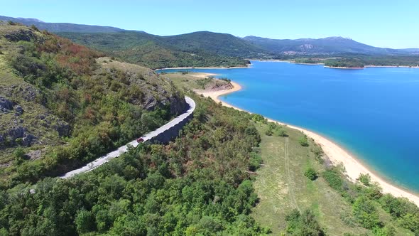 Aerial view of paved road passing artificial lake of Peruca, Croatia alt