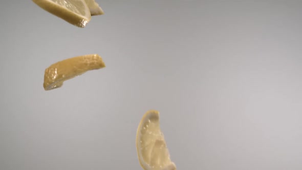 Flying fresh lemon slices passing through in front of the camera in slow motion