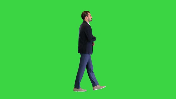 Young Handsome Business Man Walking and Talking To Himself on a Green Screen Chroma Key alt