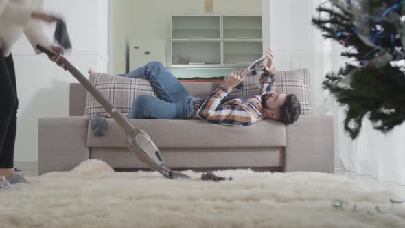 Young Caucasian Blond Woman Cleaning Up at Home, Finding Husband's Sock and Scolding Man. Lazy alt