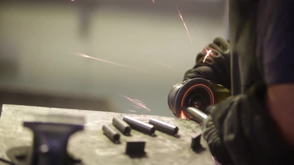 Worker polishing some metal bar with a grinder