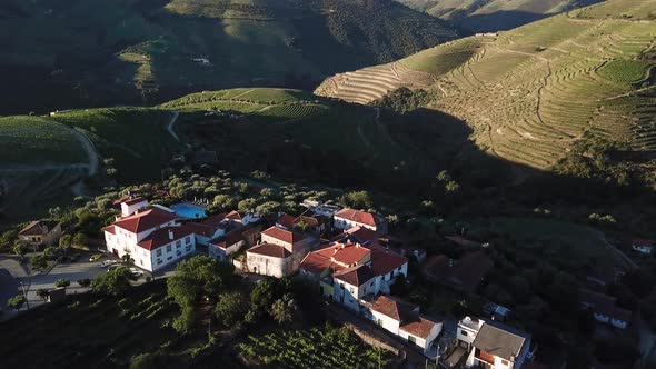 Tilting down to view a manor house atop a hill in the picturesque Douro Valley in Portugal. Aerial, alt