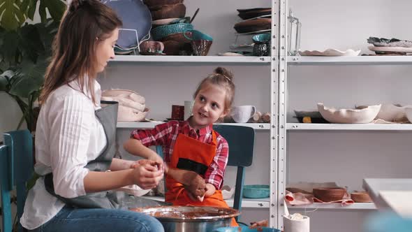 Ceramic Artist Teaching Kid How To Create Ceramics alt