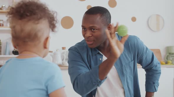 African Man Playing with Cute Toddler alt