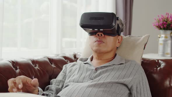 Senior man playing in virtual reality glasses until doze asleep