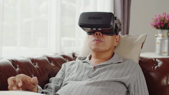 Senior man playing in virtual reality glasses until doze asleep alt