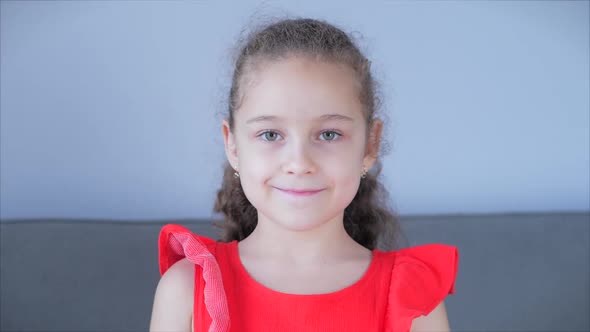 Portrait Funny Little Girl Smiling Child Looking at Camera Are Sitting on the Couch at Home, Cute alt