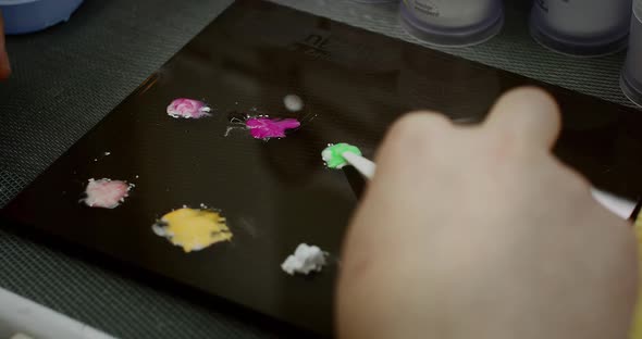 The Dental Technician Selects the Color and Applies Paint to the Denture Model Jaw with a Brush in alt