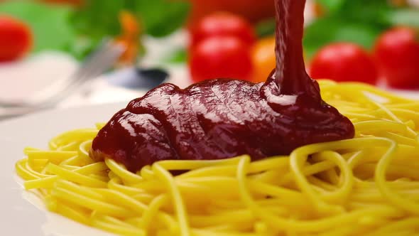 Pouring ketchup on spaghetti, tomato sauce falling on pasta, slow motion alt