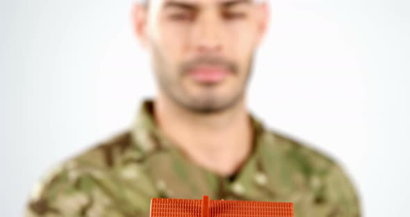 Soldier holding house model on white background alt