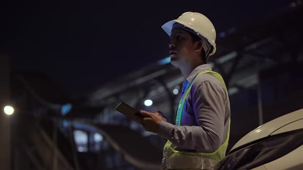 Civil engineer work inspecting architect drawing on construction site.