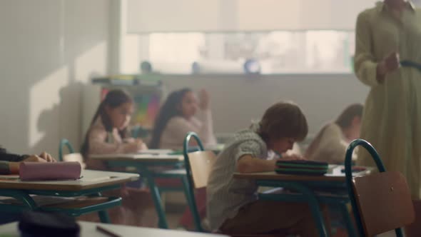 Kids Sitting at Desks in School Class alt