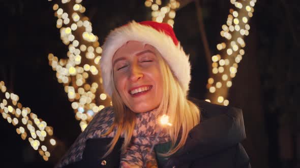 woman has closed her eyes and is making wish for Christmas. City street or park alt