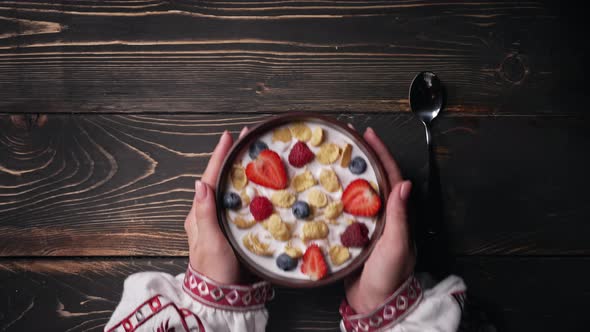 Female Hands Puts and Takes Away Breakfast  Cereal with Milk and Berries alt
