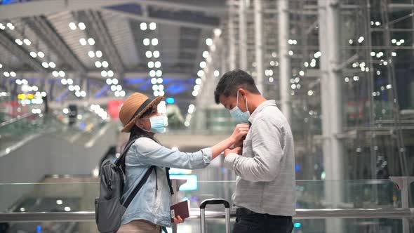 Couple Asian people in airport terminal waiting for  flight boarding