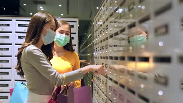 Asian woman wearing face mask. Happy woman with shopping bags alt