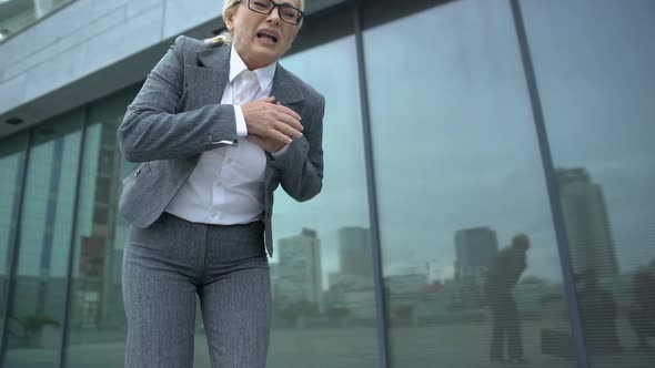 Woman in Business Suit Throwing Briefcase Feeling Strong Pain in Heart, Dystonia