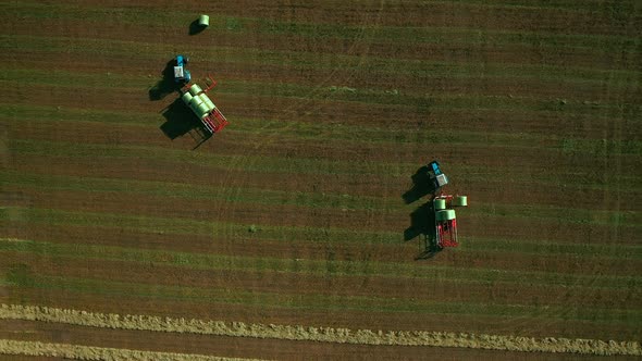 Modern Tractors Carry Haystacks. Work of Modern Agricultural Machinery in the Field. Aerial View