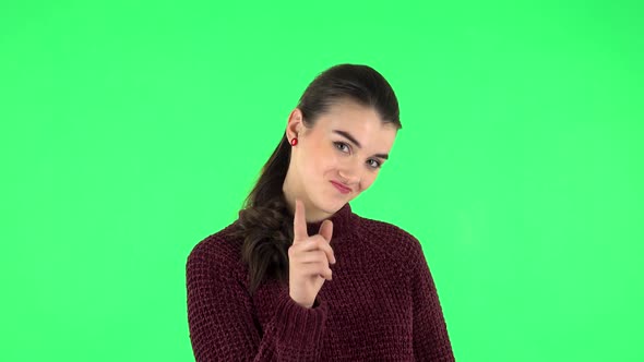 Girl Listens Carefully, Threatens with a Finger Seductively. Green Screen alt