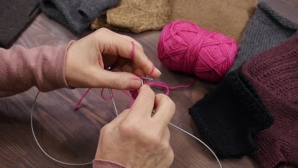 Female Hands Knitting from Pink Yarn