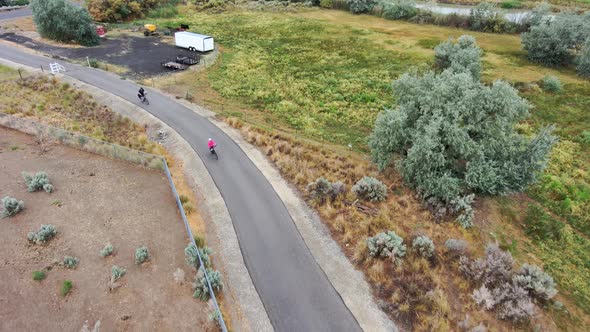 Mature couple cycling along a rural nature trail - aerial tracking view alt