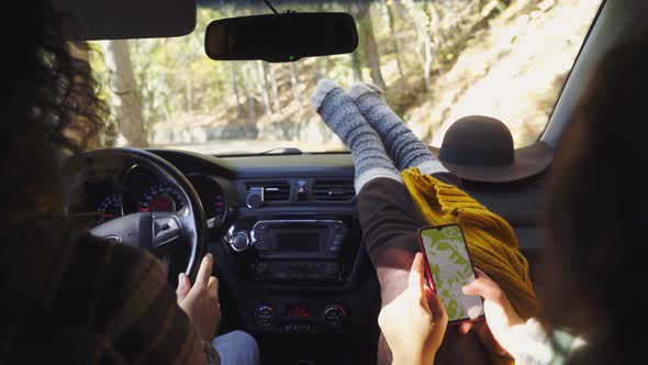 Man Drives Car Along Road Girl Friend Reads Map on Phone