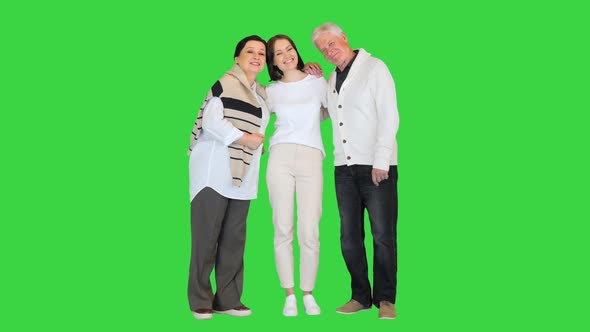 Attractive Young Woman Having Fun with Happy Older Parents on a Green Screen Chroma Key alt