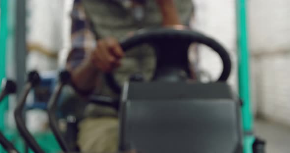 Female worker driving forklift in a warehouse alt