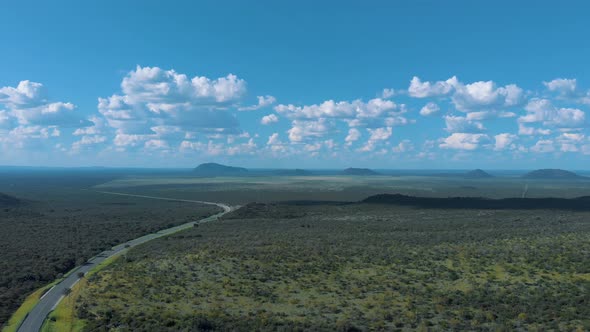 Arial drone footage of African natural landscape with road, sky and clouds, Botswana