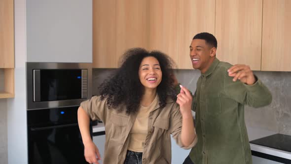 Curly Woman and Her Guy Dancing in the Kitchen and Singing