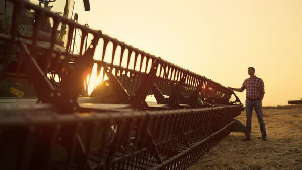 Silhouette Farmer Standing Field Observe Combine Machinery Harvest Golden Sunset alt