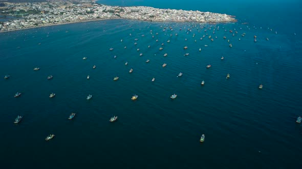 Several ships hidden from wind on sea behind overpopulated town in south Vietnam. alt