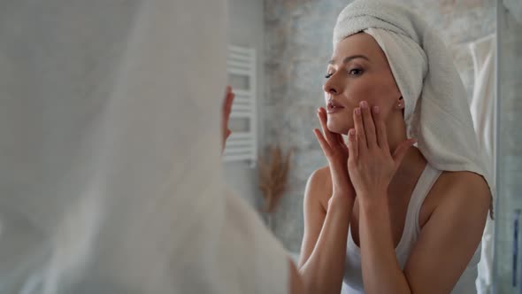 Young caucasian woman in the bathroom checking face skin condition. Shot with RED helium camera in 8 alt
