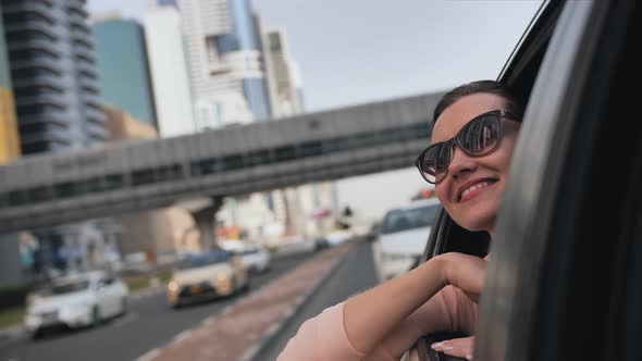 Happy Girl Enjoys the Views of Dubai From the Car Window and Sends a Kiss to the City alt